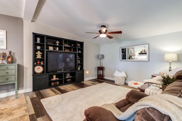 a kitchen with stainless steel appliances granite countertop a stove top oven a sink dishwasher a dining table and chairs with wooden floor