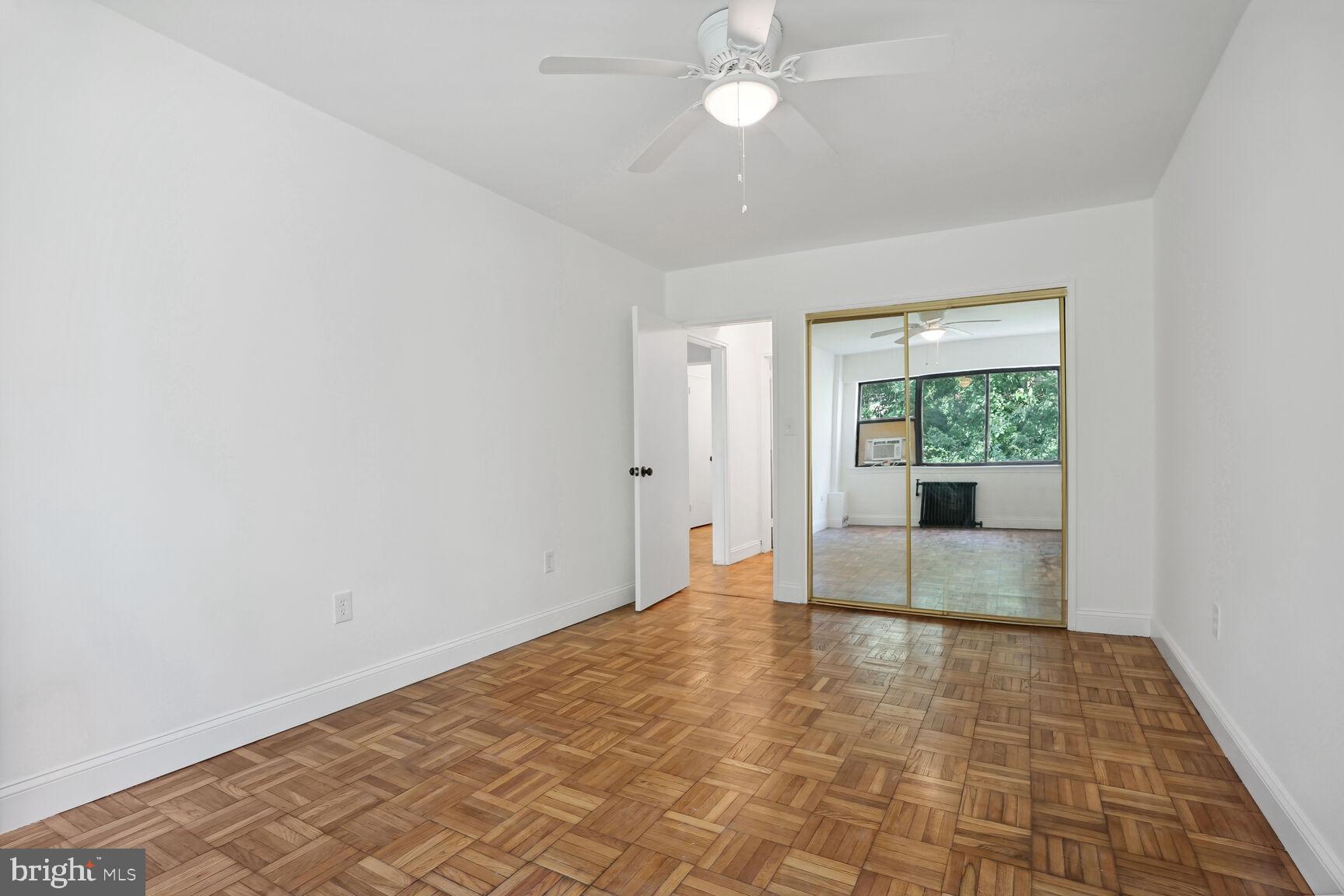 3901 Tunlaw Road Northwest, Unit 502 Washington, DC 20007 - Photo 15 of 34 wooden floor in an empty room with a window