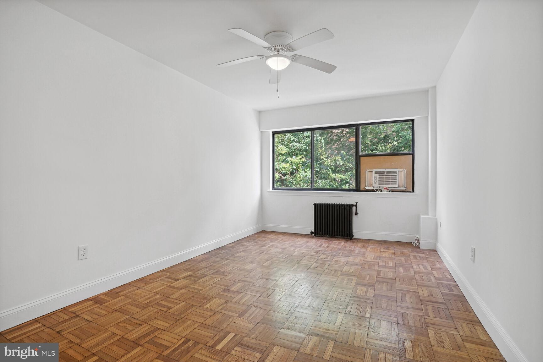 3901 Tunlaw Road Northwest, Unit 502 Washington, DC 20007 - Photo 18 of 34 an empty room with windows and ceiling fan