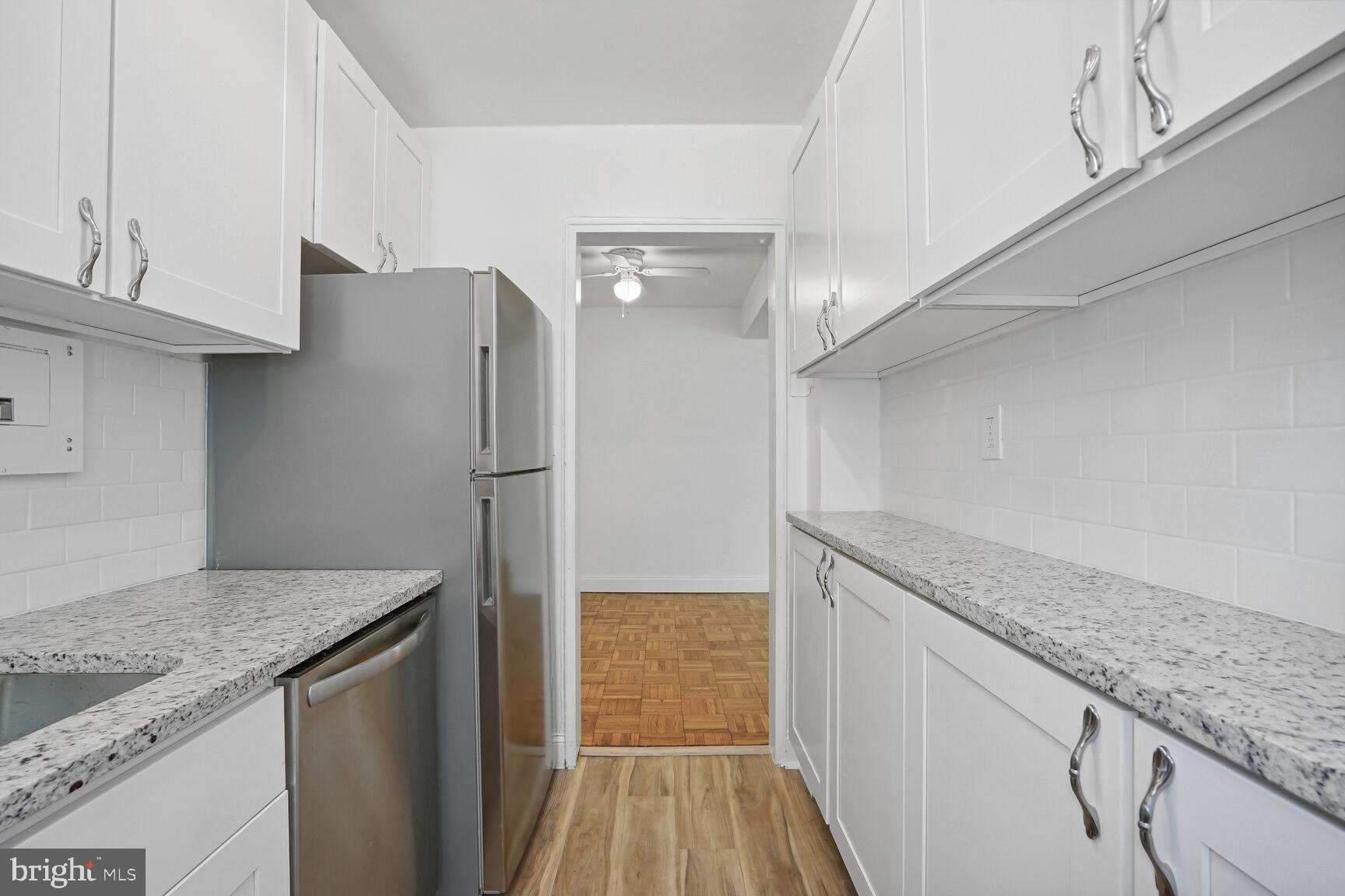 3901 Tunlaw Road Northwest, Unit 502 Washington, DC 20007 - Photo 7 of 34 a kitchen with granite countertop a refrigerator and a sink