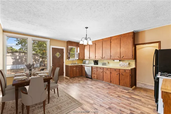 a kitchen with refrigerator cabinets dining table and chairs