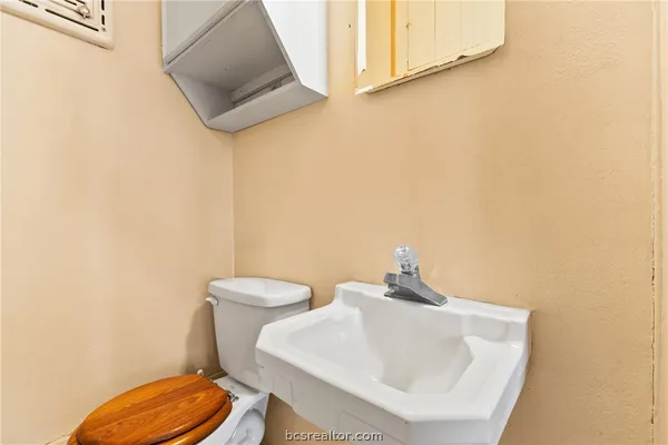 a bathroom with a toilet a sink and mirror