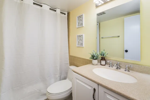 a bathroom with a granite countertop sink toilet and shower