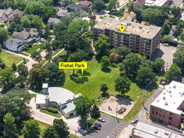 a aerial view of a house with swimming pool and large trees