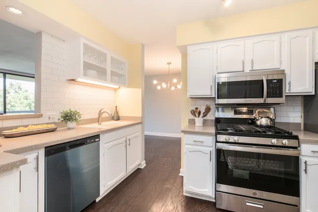 a kitchen with stainless steel appliances a stove microwave and sink