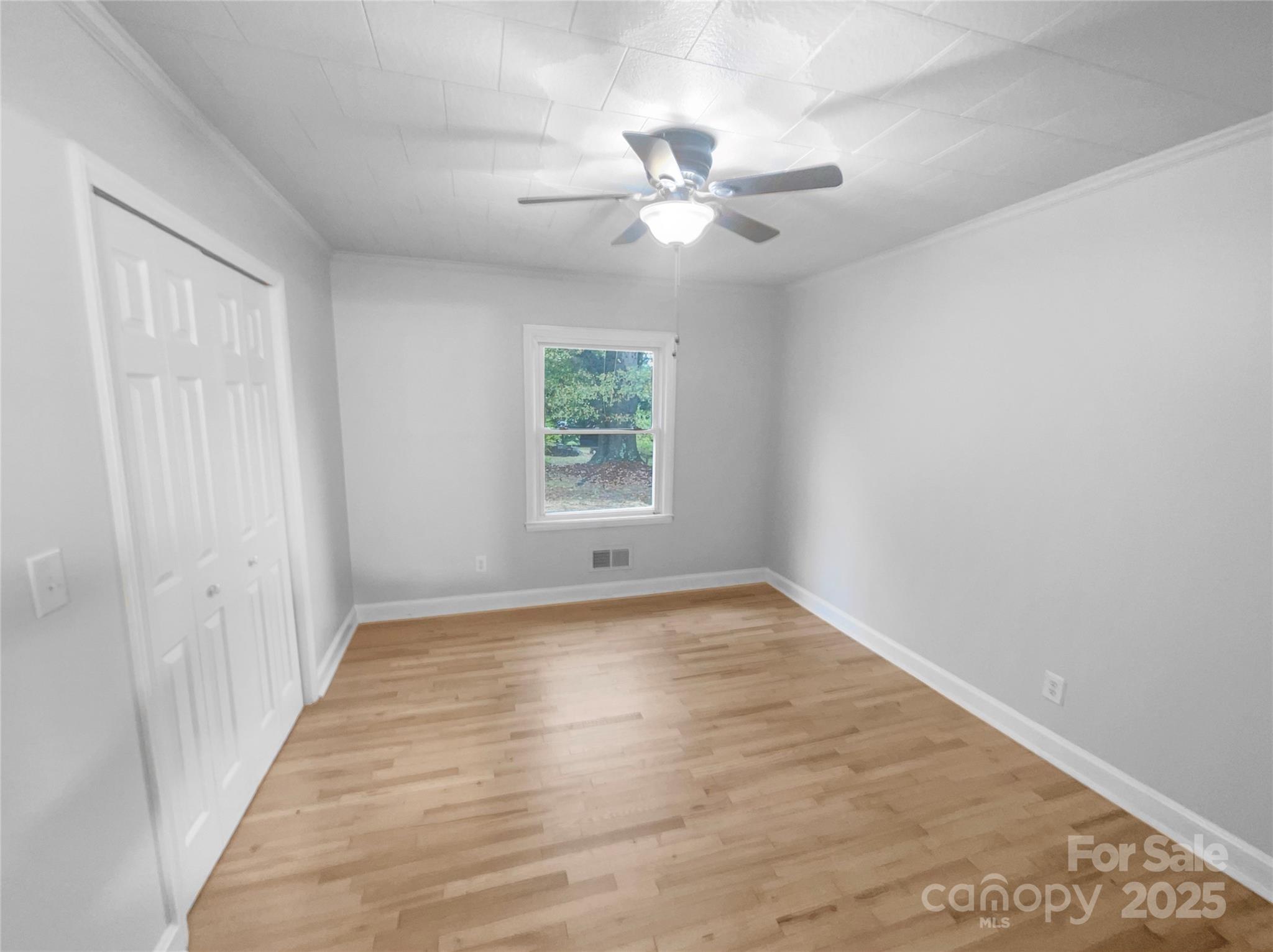 2009 Hickory Grove Road Gastonia, NC 28056 - Photo 4 of 20 a view of an empty room with wooden floor and a window