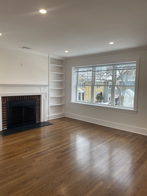 29 Crescent Road, Unit 29 Belmont, MA 02478 - Photo 3 of 21 an empty room with wooden floor fireplace and windows