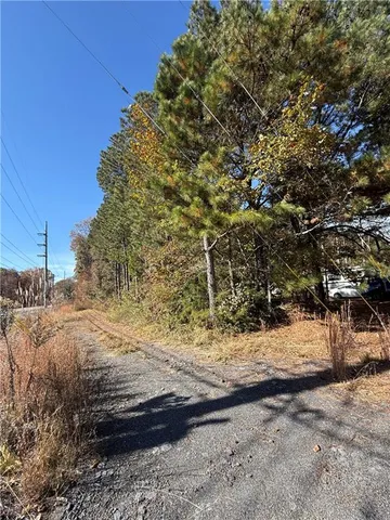 a view of dirt yard with a large tree