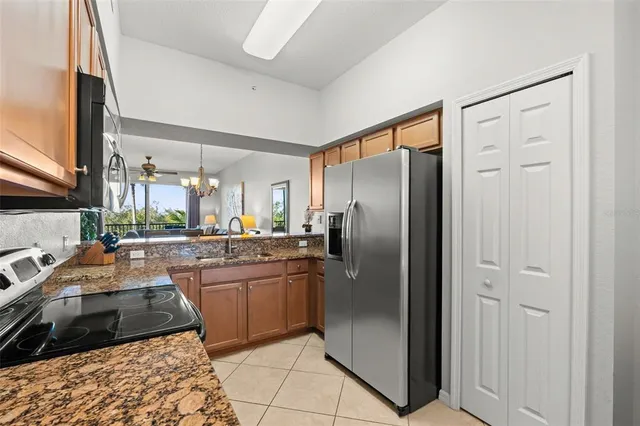a kitchen with stainless steel appliances granite countertop sink stove and refrigerator