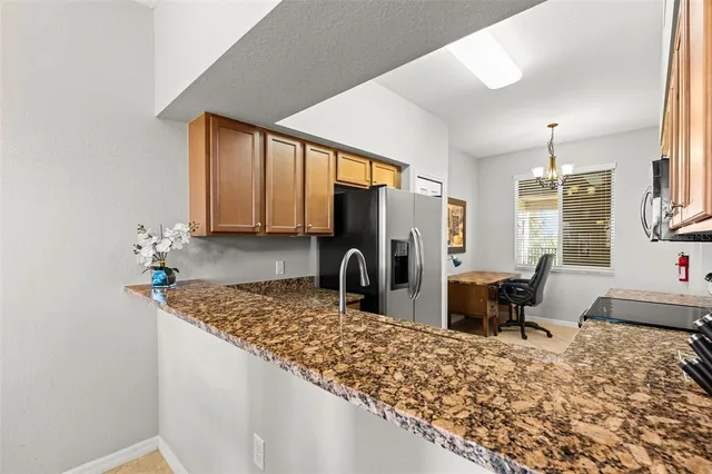 a kitchen with stainless steel appliances granite countertop a sink refrigerator and cabinets