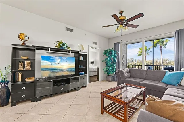 a living room with furniture a flat screen tv and a floor to ceiling window