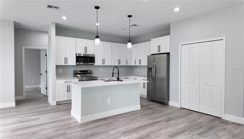 7 Spring Pass Ocala, FL 34472 - Photo 21 of 35 a kitchen with kitchen island white cabinets and stainless steel appliances