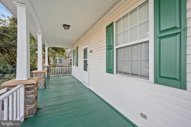 a view of a porch with wooden floor and a backyard