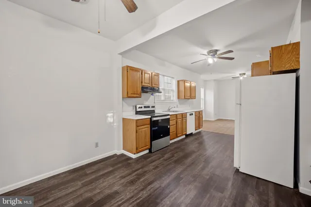 a view of a kitchen with a sink a ceiling fan and wooden floor