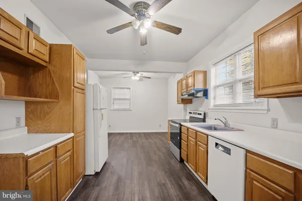 a kitchen with a sink a refrigerator and wooden floor