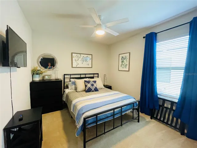 a bedroom with a bed and a flat tv screen on a dresser