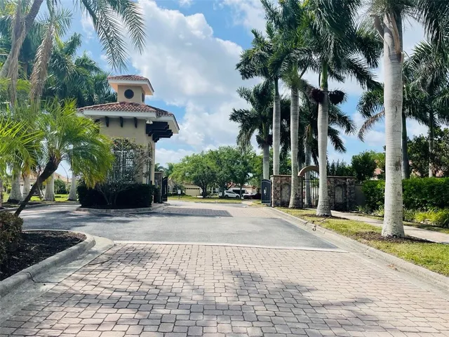 a view of a house with a yard and palm trees
