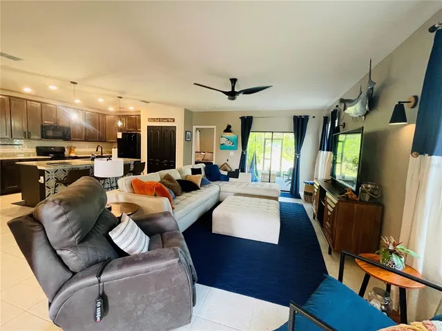 a living room with furniture a flat screen tv and a large window