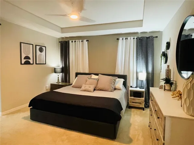 a bedroom with a bed window and a flat screen tv