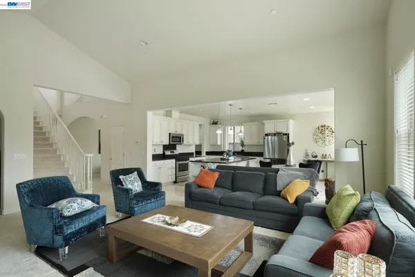 a living room with furniture kitchen view and a window