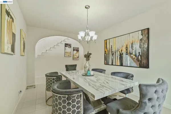 a dining room with wooden floor a chandelier a wooden table and chairs
