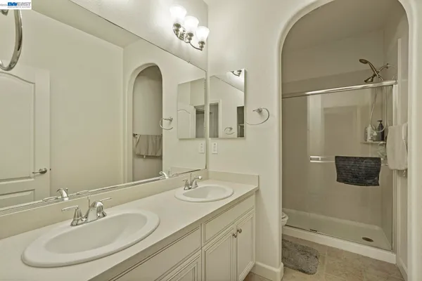 a bathroom with a shower sink and mirror