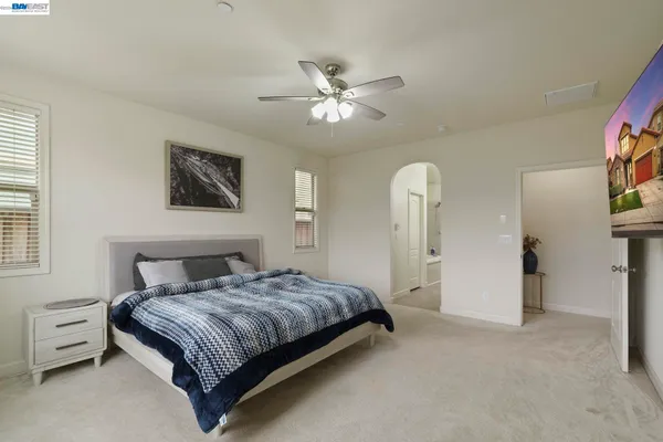 a bedroom with a large bed and a chandelier