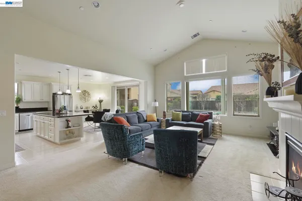 a living room with fireplace furniture and a large window
