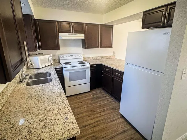 a kitchen with a refrigerator sink and stove top oven