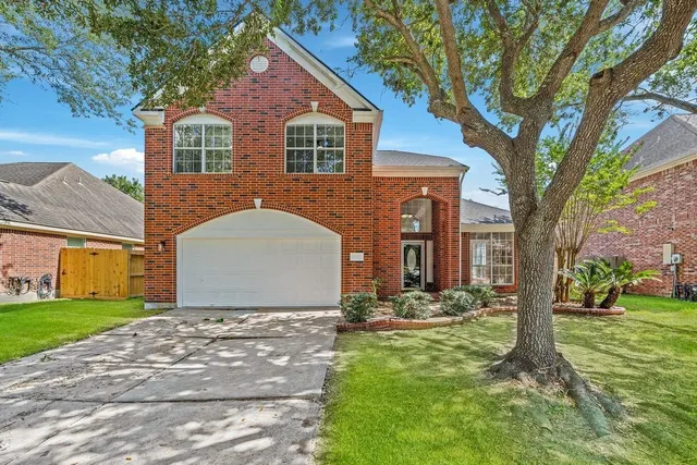 a front view of house with yard and trees