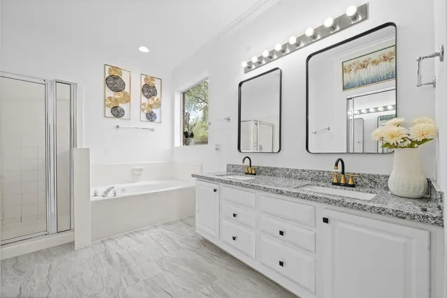 a bathroom with a granite countertop double vanity sink and a mirror