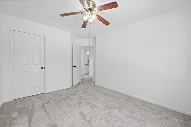 an empty room with closet and a chandelier fan