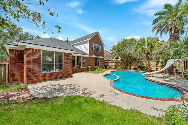 a view of a house with pool and chairs