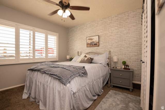 340 West 100 N Street Beaver, UT 84713 - Photo 14 of 37 Bedroom with brick wall, dark carpet, ceiling fan, and a textured ceiling