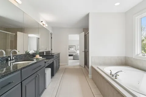 a large bathroom with a tub a sink and mirror