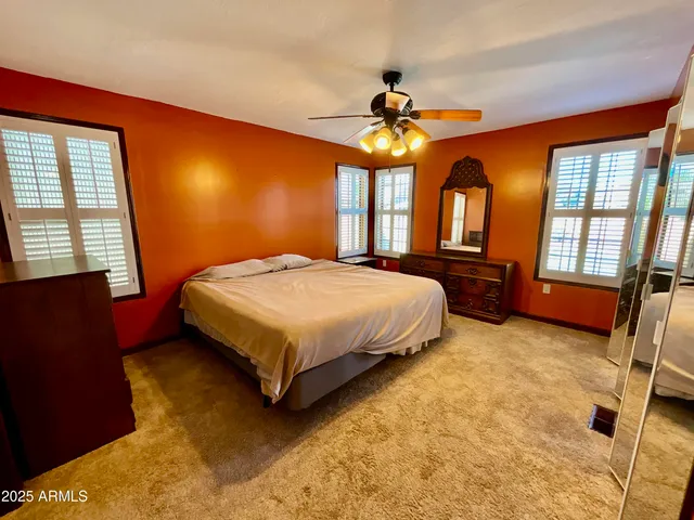 a bedroom with a large bed and a chandelier