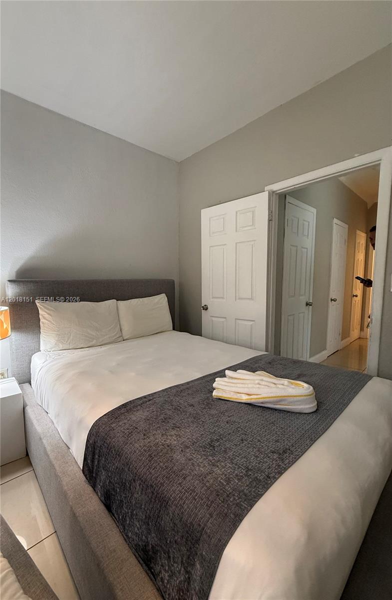 7710 Harding Avenue, Unit 1 Miami Beach, FL 33141 - Photo 10 of 10 a bedroom with a bed and a couch
