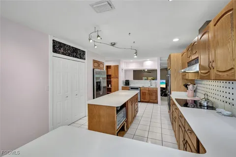 a large kitchen with a large counter top appliances and a ceiling fan
