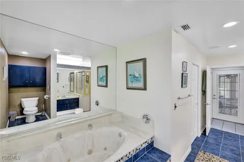 a bathroom with a tub a sink and a large mirror