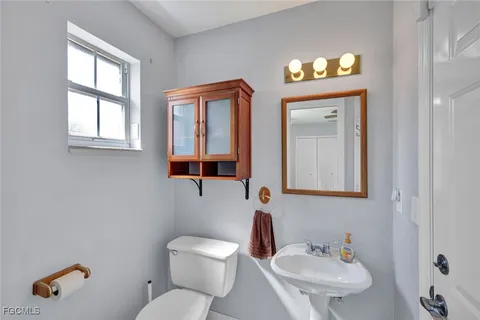 a bathroom with a toilet sink and mirror