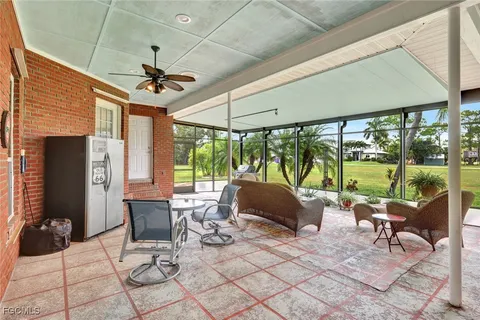 a living room with patio furniture and a floor to ceiling window