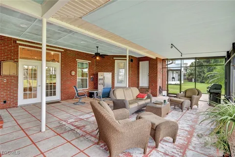 a living room with furniture and large windows