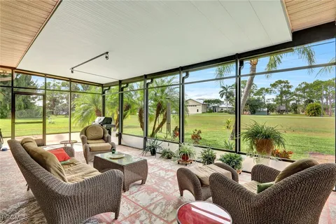 a living room with furniture and a floor to ceiling window