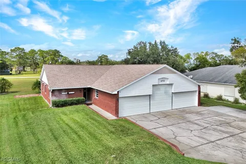a aerial view of a house next to a big yard and large tree