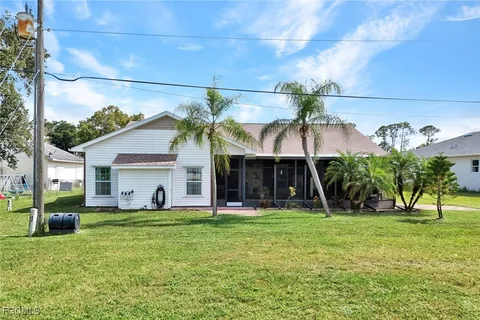 a view of a house with backyard and a tree