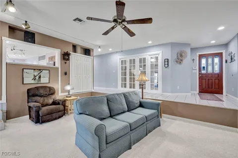 a living room with furniture ceiling fan and a window