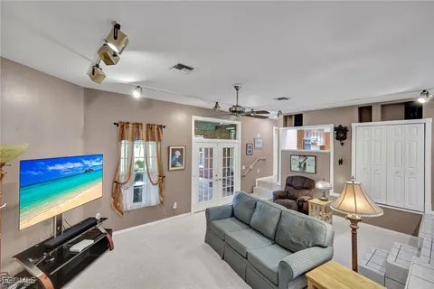 a living room with furniture a flat screen tv and a window