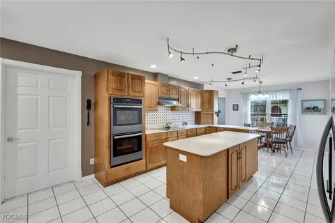 a kitchen with stainless steel appliances granite countertop a refrigerator and a stove top oven