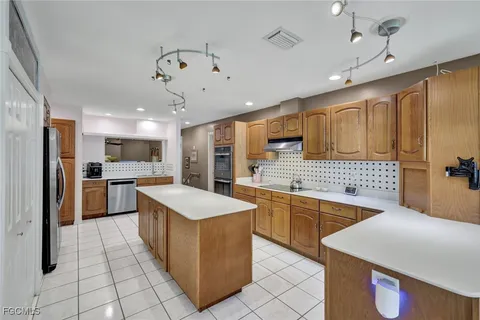 a kitchen with stainless steel appliances granite countertop a sink counter space cabinets and a large window