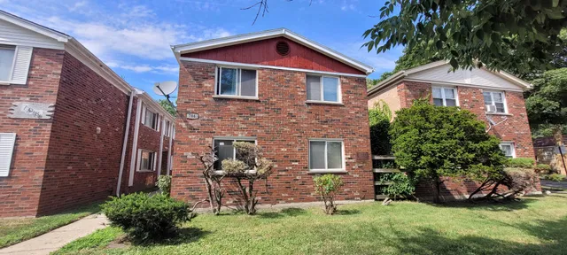 a front view of a house with a yard and potted plants